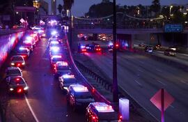 Vehículos policiales se alinean en la carretera al atardecer durante las protestas contra las redadas migratorias cerca del Edificio Federal Edward R. Roybal en Los Ángeles, California, EE. UU.