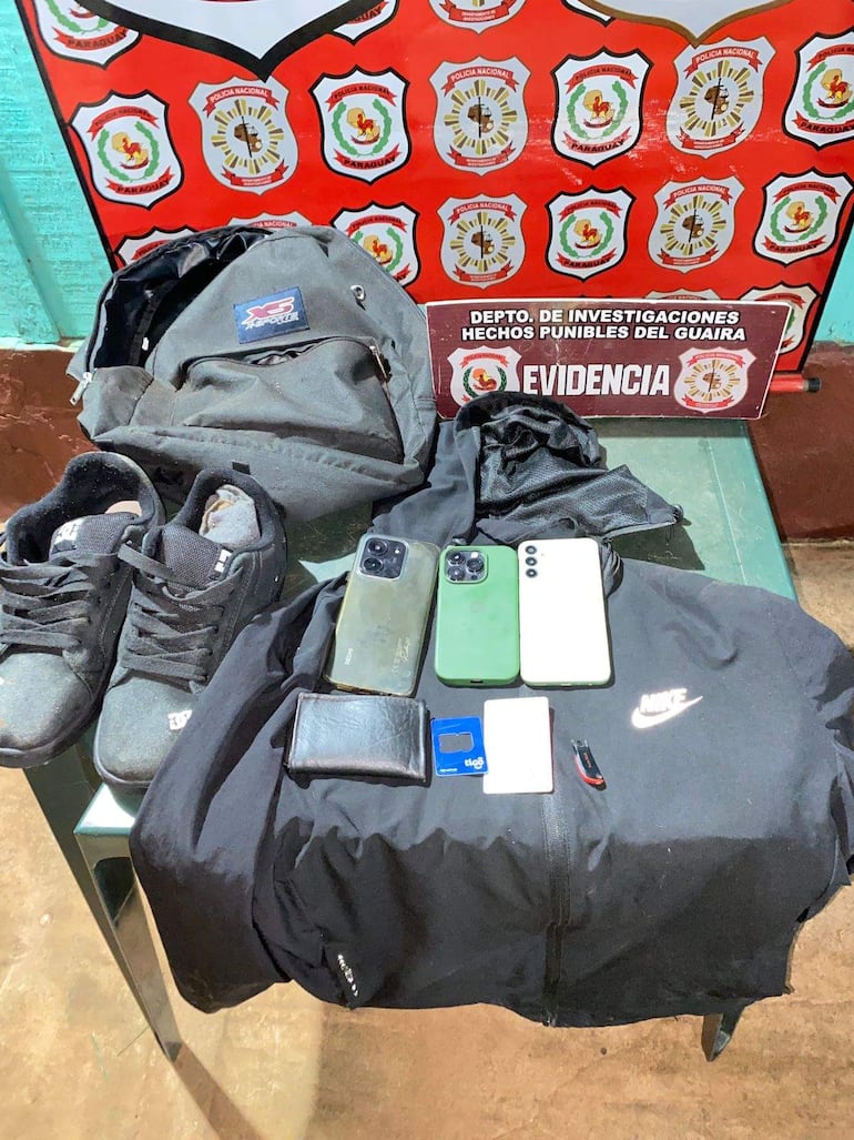 Mesa con teléfonos móviles, billetera negra y chaqueta Nike que fueron incautados durante  allanamientos simultáneos en Guairá y Caaguazú, investigando el asesinato de la alemana Olga Brodkord.