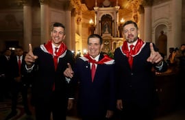 Peña, Cartes y Alliana sonríen en trajes oscuros con bufandas rojas, posando en un entorno ceremonial.