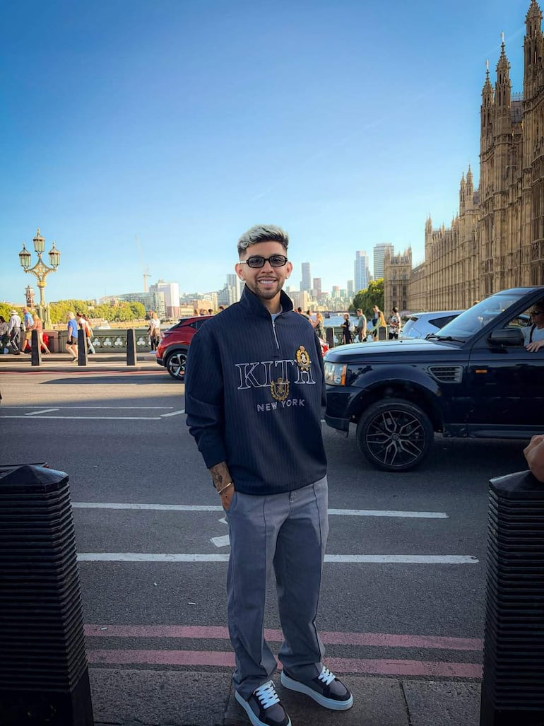 Ramón Sosa con sudadera oscura sonríe en la calle, junto a Julio Enciso. Edificios modernos de fondo.