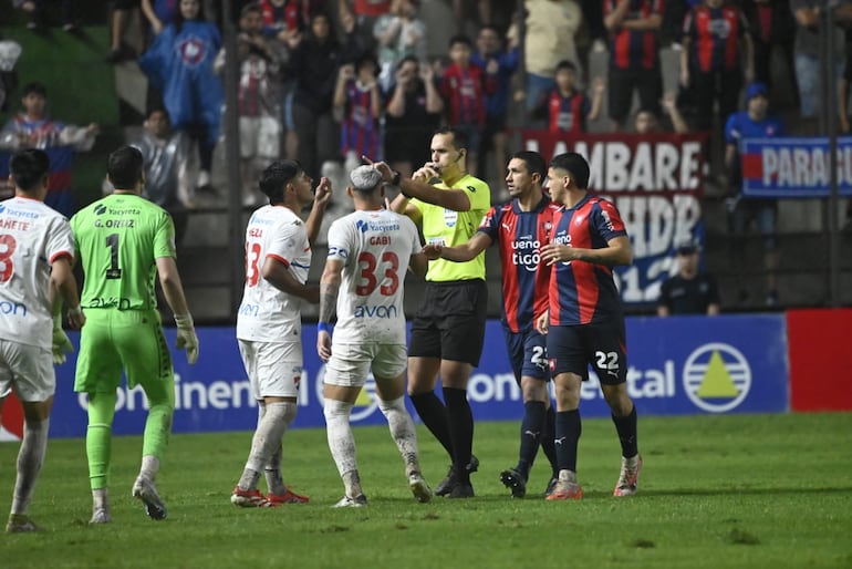 El árbitro David Ojeda es llamado al VAR para revisar el penal que sancionó por mano de Gastón Giménez, jugador de Cerro Porteño, en el partido frente a Nacional por la fecha 18 del torneo Clausura 2025 de la Primera División de Paraguay en el estadio Arsenio Erico, en Asunción, Paraguay.