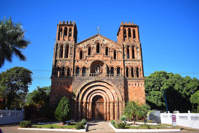 La iglesia de Ybaroty destaca por su arquitectura de piedra y torres, rodeada de vegetación.