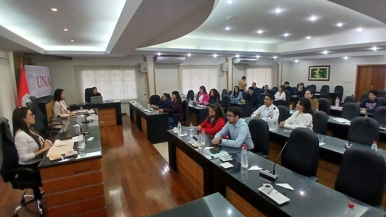 Tres mujeres ponentes sentadas tras una mesa larga, en un ambiente formal con audiencia atenta en la sala de conferencias.