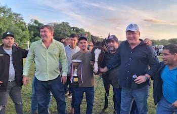 Festejando con la copa y Mbokaja'i la gente de las caballerizas La Gringa y Divino Niño Jesús, en la gran victoria en el Aniversario del Hipódromo Paso Puente.