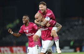 Carlos González (c-abajo), Mateo Carabajal (c-arriba) y Justin Lerma de independiente celebran un gol este martes, en un partido de la Copa Libertadores entre Libertad e Independiente del Valle en el estadio La Huerta en Asunción (Paraguay).