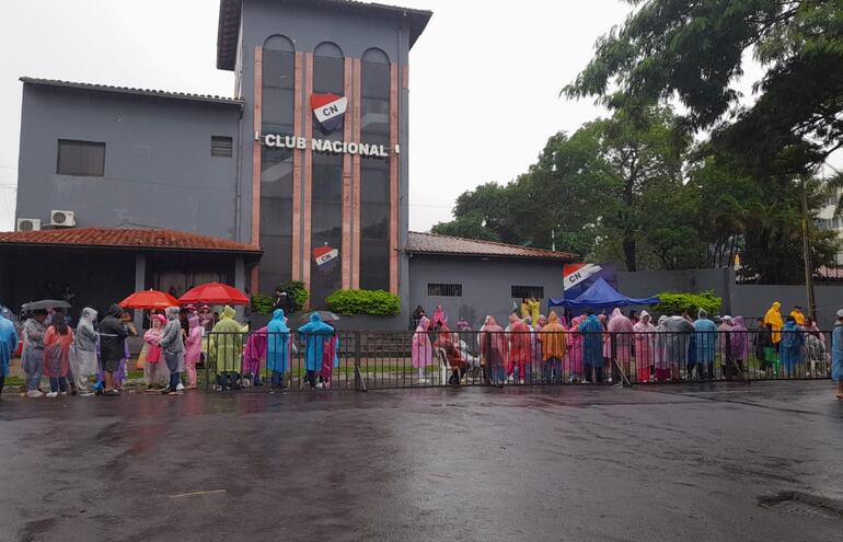 Bajo la lluvia esperan la apertura de portones para el ingreso al concierto de Karol G en Paraguay.