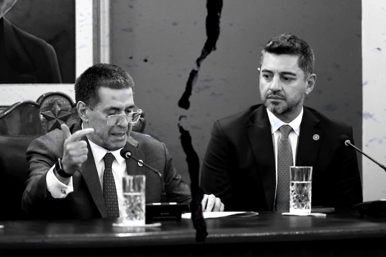 Alliana gesticula seriamente frente a un micrófono, mientras Cartes lo observa con expresión neutral en un ambiente formal.