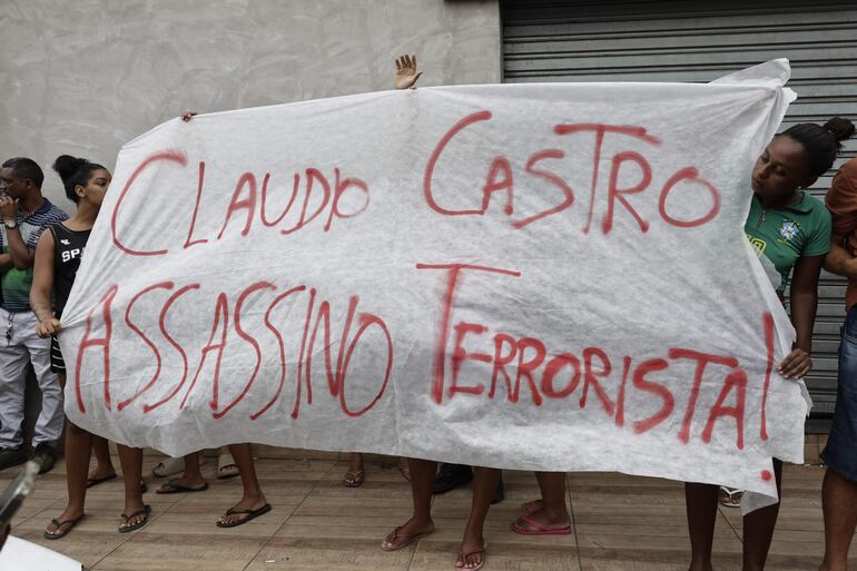 Personas sostienen un cartel contra el gobernador de Río de Janeiro, Claudio Castro, este miércoles en Río de Janeiro (Brasil). 