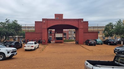 Edificio de ladrillo rojo con aparcamiento vacío, sin personas visibles en la escena.