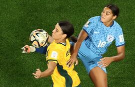 La británica Jessica Carter (d) intenta puntear la pelota, que la australiana Sam Kerr quiere dominarla con el pecho.