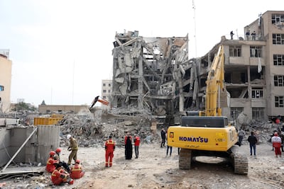Equipos de rescate iraníes trabajan entre los escombros de edificios residenciales dañados en el centro de Teherán, Irán, el 12 de marzo de 2026.