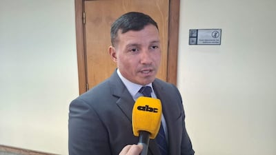 Aldo Cantero vestido con traje gris y corbata, habla a un micrófono en un entorno formal moderadamente iluminado.