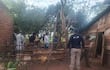 Hombres en uniforme policial y camisa blanca en área rural, investigando en un entorno natural con árboles y vegetación.