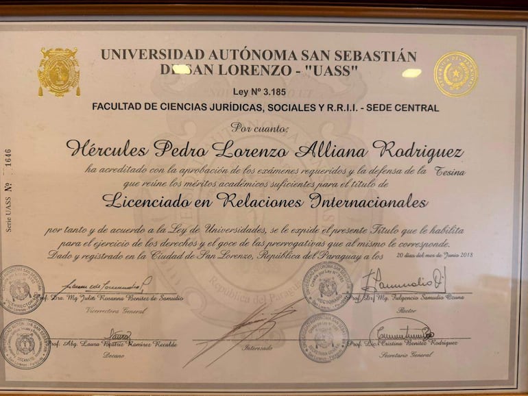 Diploma enmarcado que acredita a Hércules Pedro Lorenzo Alliana Rodríguez como Licenciado en Relaciones Internacionales, con sellos y firmas institucionales.