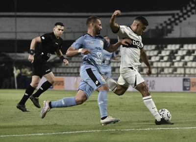 Marcos Gómez (d), futbolista de Olimpia, lucha por el balón con William Candia, jugador de Resistencia, en el partido por la jornada 13 del torneo Clausura 2023 del fútbol paraguayo en el estadio Manuel Ferreira.