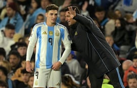 Argentina's coach Lionel Scaloni (R) gives instructions to forward Julian Alvarez during the 2026 FIFA World Cup South American qualifiers football match between Argentina and Chile at the Mas Monumental stadium in Buenos Aires on September 5, 2024. (Photo by JUAN MABROMATA / AFP)