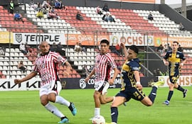 El extremo de Sportivo Trinidense, Tobías Morínigo se perfila para sacar el disparo ante la cobertura del experimentado zaguero del Sportivo San Lorenzo, Teodoro Paredes.