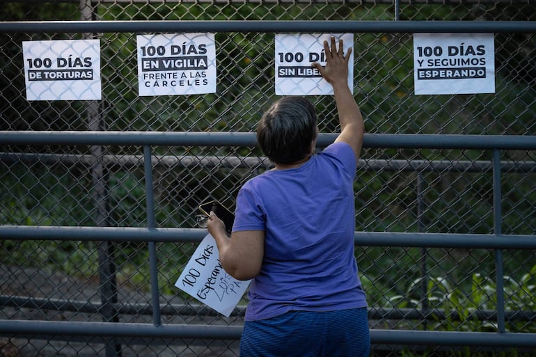 Una persona pega carteles previo a una vigilia afuera de la cárcel El Rodeo I este sábado, en Guatire.
