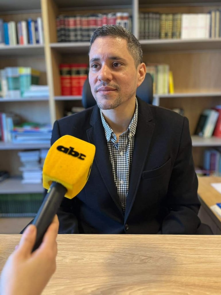Federico Legal sentado en oficina, camisa de cuadros, saco negro, expresión neutral, mientras un micrófono de ABC es sostenido en el encuadre.