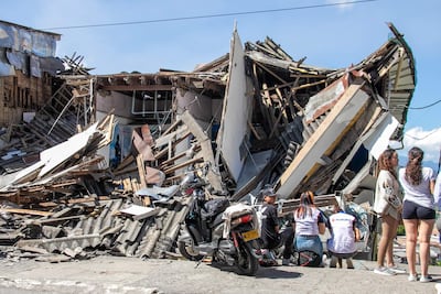 Personas observan una edificación destruida por un terremoto de magnitud 7,4 este lunes, en Manizales (Colombia). El presidente de Colombia, Abelardo de la Espriella, afirmó que el terremoto que sacudió la mayor parte del país, deja una cifra parcial de 111 fallecidos y una gran destrucción en al menos cinco departamentos.