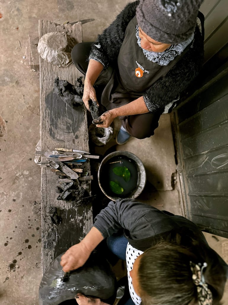 Ceramistas trabajan en el moldeado del ñai'u (barro negro).