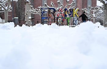 Un hombre camina por la plaza nevada frente a la iglesia de San Pablo en Fráncfort del Meno, Alemania Occidental.