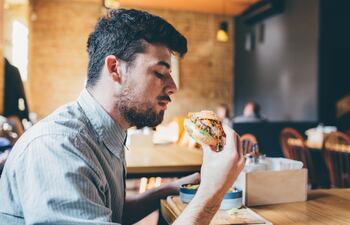 Un hombre comiendo una hamburguesa