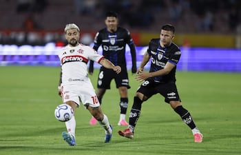 El paraguayo Hugo Quintana (d) de Independiente del Valle disputa el balón con Giorgian De Arrascaeta de Flamengo este jueves, en un partido de ida de cuartos de final de la Copa Libertadores entre Independiente del Valle y Flamengo en el estadio Olímpico Atahualpa, en Quito (Ecuador).