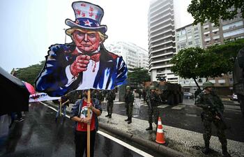 Un manifestante sostiene una figura de cartón del presidente electo de Estados Unidos, Donald Trump, vestido como el Tío Sam, durante una marcha en apoyo del pueblo palestino en la playa de Copacabana en Río de Janeiro, Brasil.