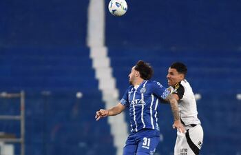 El delantero de Godoy Cruz, Agustín Auzmendi, y el defensor paraguayo de Atlético Mineiro, Junior Alonso, pelean por el balón durante el partido de vuelta de los octavos de final de la Copa Sudamericana entre el Godoy Cruz de Argentina y el Atlético Mineiro de Brasil, en el estadio Feliciano Gambarte en Godoy Cruz, provincia de Mendoza.