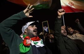 Manifestantes portan banderas iraníes y retratos del líder supremo iraní, el ayatolá Alí Jamenei, durante una protesta contra los ataques estadounidenses e israelíes en varias ciudades de Irán.