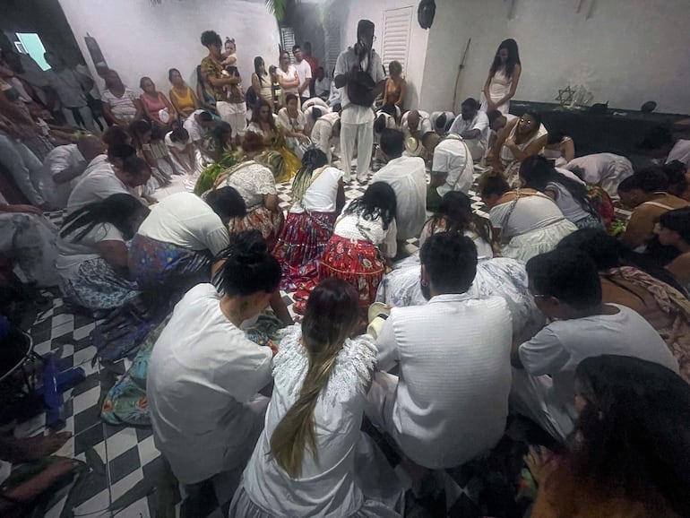 El juremero Álvaro Dutra se encuentra en el centro, rodeado de seguidores de rodillas durante una extensa ceremonia con danza, tambores y cánticos en honor a la Jurema y a los espíritus que creen invocar, en Planaltina, Distrito Federal, Brasil.
