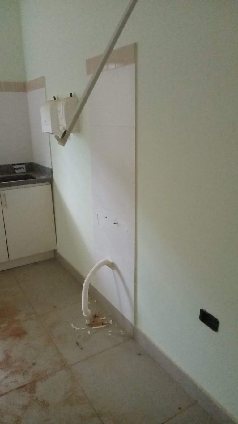 Ambiente interior de la USF De La Victoria en estado de abandono, con mesada y paredes dañadas en tonos verdes.