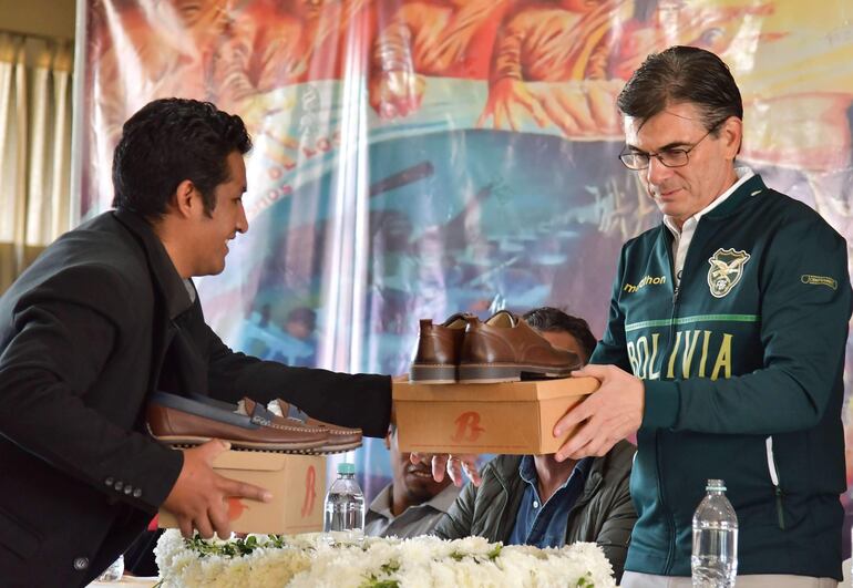 El presidente de Bolivia, Rodrigo Paz, recibe unos zapatos durante una reunión con el sector fabril, en Quillacollo (Bolivia).