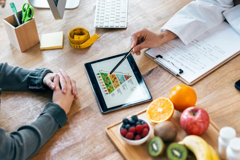 Nutricionista explica un sistema de alimentación a su paciente.