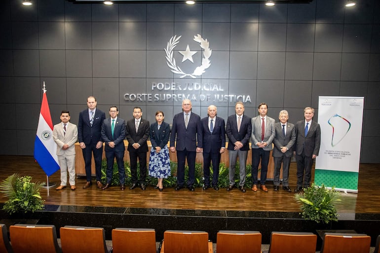 Grupo de diez personas, todos con trajes formales, en un entorno institucional de la Corte Suprema, transmiten calma y profesionalismo.