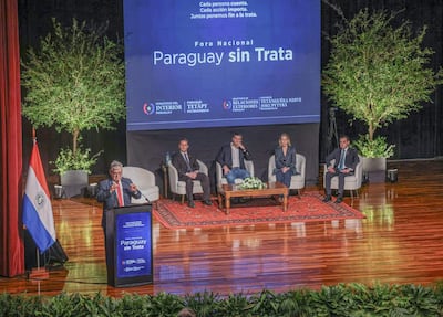 Leticia Ocampos en atuendo elegante observa a Santiago Peña, quien habla en micrófono, rodeados de autoridades y ambiente formal.