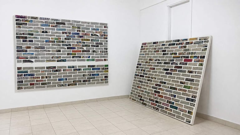 Espacio interior con paneles de recortes de periódicos, iluminación suave en un ambiente minimalista.