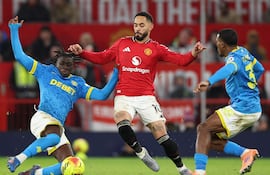 Matheus Cunha (C), del Manchester United, en acción contra Mateus Mane (I), de los Wolves, y Jackson Tchatchoua (D), durante el partido de la Premier League inglesa entre el Manchester United y el Wolverhampton Wanderers, en Manchester, Gran Bretaña.