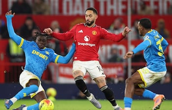 Matheus Cunha (C), del Manchester United, en acción contra Mateus Mane (I), de los Wolves, y Jackson Tchatchoua (D), durante el partido de la Premier League inglesa entre el Manchester United y el Wolverhampton Wanderers, en Manchester, Gran Bretaña.