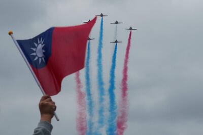 Una persona con una bandera de Taiwán observa un show aéreo durante las celebraciones del Día Nacional de Taiwán, este jueves en Taipéi.