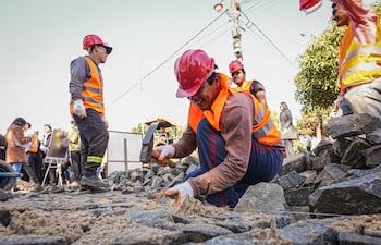 En primer plano, un obrero trabaja en la colocación de empedrado en Hernandarias, como parte del “Plan 1000” que contempla 1.000 km de caminos en los 17 departamentos y la capital.