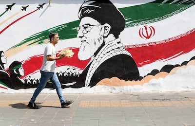 Un hombre camina frente a un mural que retrata al ayatolá Alí Jameneí en Teherán.