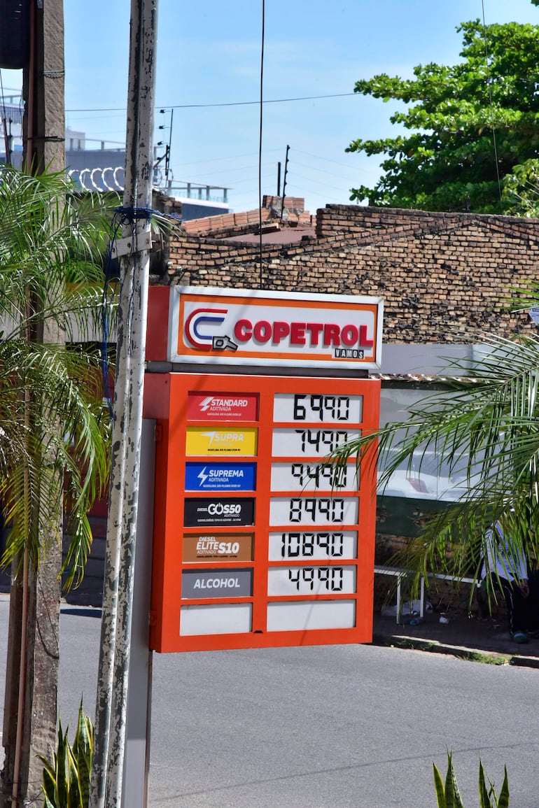 Cartel en estación de servicio Copetrol, con precios de combustibles destacados y entorno urbano visible en Colon y Azara.
