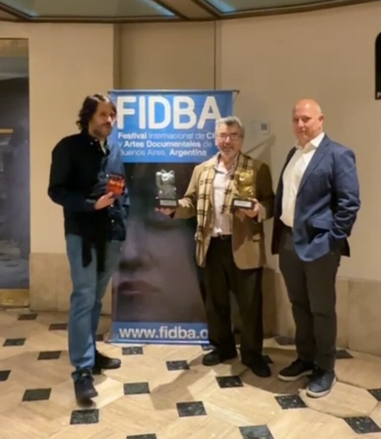 El cineasta paraguayo Hugo Gamarra (centro) posa con los dos reconocimientos que obtuvo en el Fidba.