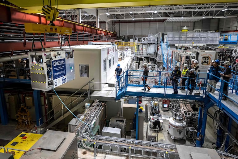 Un dispositivo portátil de trampa de Penning criogénica especialmente diseñado, cargado con una nube de 92 antiprotones, es transferido a un camión durante una prueba de conducción exitosa del primer sistema de transporte de antimateria del mundo, realizada por el experimento BASE-STEP del CERN, que trasladó antiprotones por carretera a través del sitio principal de la organización, en Meyrin, cerca de Ginebra, el 24 de marzo de 2026.