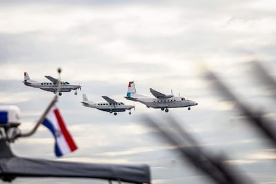 Aviones en vuelo alineados, uno con el diseño 'Poder Judicial de Paraguay', sobre un cielo nublado.