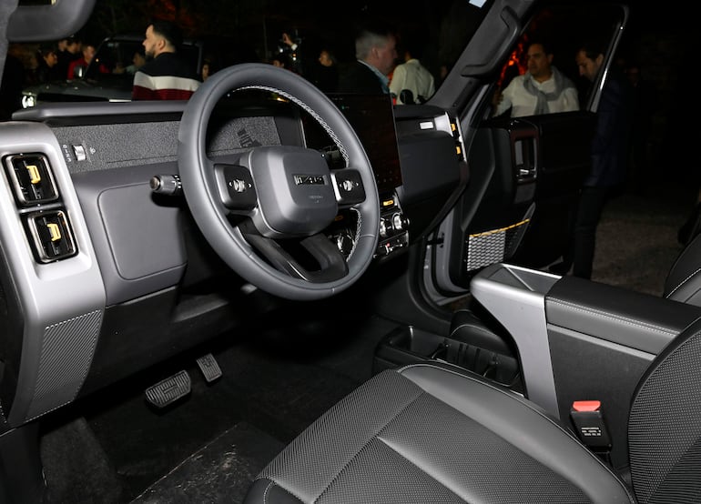 Interior de un vehículo moderno con volante, panel de instrumentos y asientos, sin personas visibles en primer plano.