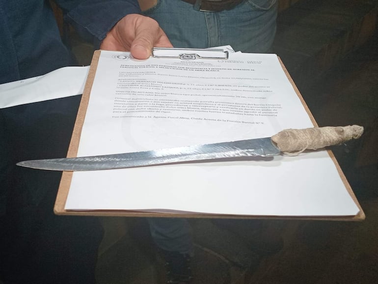Objeto metálico envuelto sobre un documento con texto oficial, en un ambiente que parece ser una oficina.