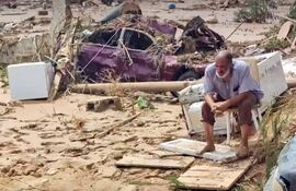 Un hombre sentado entre los daños causados por una inundación generada por la tormenta "Daniel" en Derna, Libia.